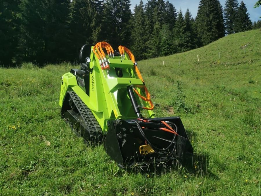 Kompakt-Raupenlader auf einer Bergwiese